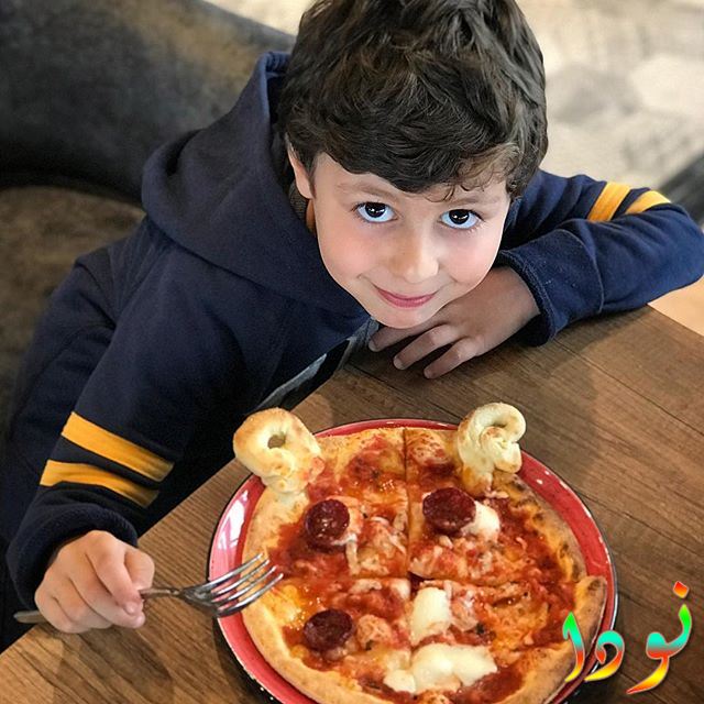 الفنان الصغير دمير بيرينجي يأكل البيتزا